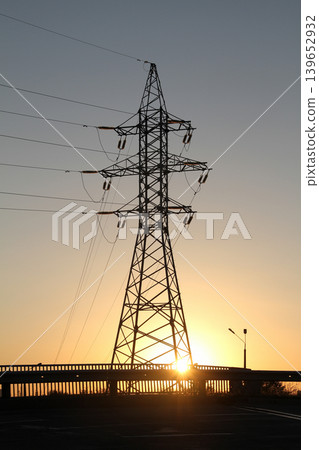 Silhouette of Power Tower near Road Bridge at Sunset 139652932