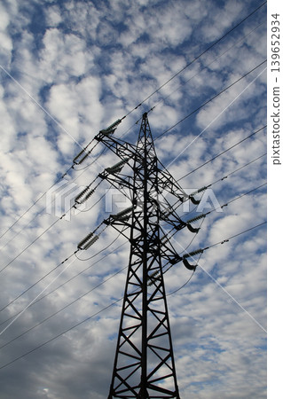 Vertical Image of Single Metal Power Line Tower Under Cloudy Sky 139652934