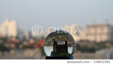 Miniature castle in toy glass globe with real cityscape soft focus Miniature castle in toy glass globe with real cityscape soft focus 139652992