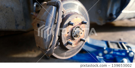 Replacing brake discs and drums during car repair process at a garage workshop 139653002