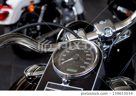 Speedometer and chrome parts on motorcycle handlebar in motorbike shop Speedometer and chrome parts on motorcycle handlebar in motorbike shop 139653034