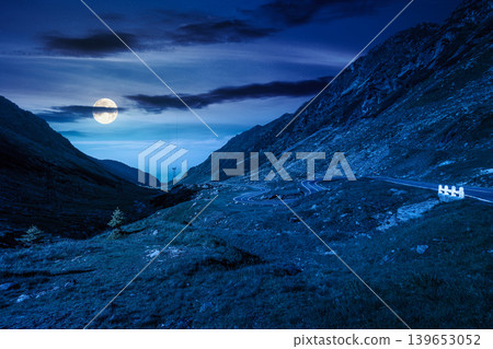 road through mountains winding uphill at night. full moon over popular highway travel destination of Romania. mysterious view of mountain on summertime weather. road journey landscape 139653052