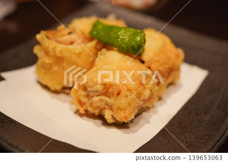 Deep-fried spring rolls made with Kyoto-style yuba (tofu skin), close-up of the cross-section, served with shishito peppers. Deep-fried spring rolls made with Kyoto-style yuba (tofu skin), close-up of the cross-section, served with shishito peppers. 139653063