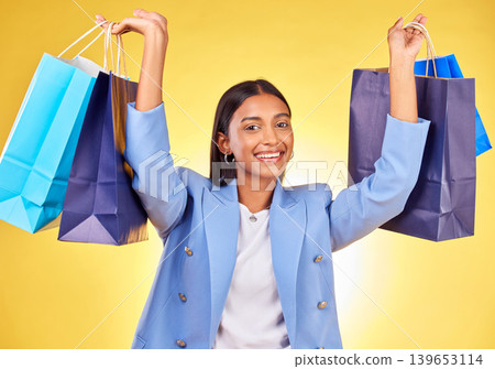 Excited business woman, shopping bag and studio portrait with smile, success and deal by yellow background. Happy customer experience, gift and discount with retail therapy, sale and fashion choice 139653114