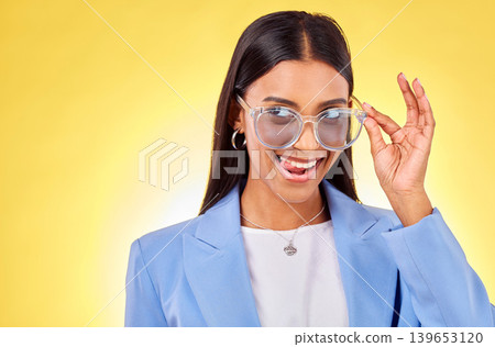 Funny, woman and sunglasses with tongue out, comedy and silly face in a studio. Yellow background, crazy and young female person with modern fashion, trendy cool style and creative work clothing Funny, woman and sunglasses with tongue out, comedy and silly face in a studio. Yellow background, crazy and young female person with modern fashion, trendy cool style and creative work clothing 139653120