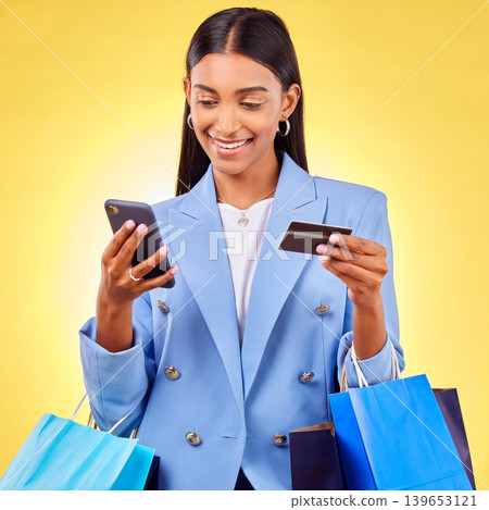 Woman, phone and credit card with shopping bag, studio and fintech for payment by yellow background. E commerce, smartphone and banking info with smile, discount and sale on mobile app for fashion Woman, phone and credit card with shopping bag, studio and fintech for payment by yellow background. E commerce, smartphone and banking info with smile, discount and sale on mobile app for fashion 139653121