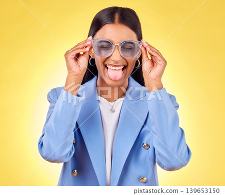 Funny, woman smile and sunglasses with tongue out, comedy and silly face in a studio. Yellow background, crazy and female person with modern fashion, trendy cool style and creative work clothing Funny, woman smile and sunglasses with tongue out, comedy and silly face in a studio. Yellow background, crazy and female person with modern fashion, trendy cool style and creative work clothing 139653150