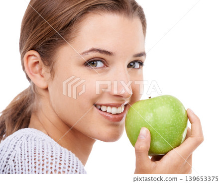 Woman, portrait and eating apple, nutrition and gut health with snack or meal, diet for weight loss on white background. Healthy food, wellness and fruit, vegan and organic with smile in studio 139653375