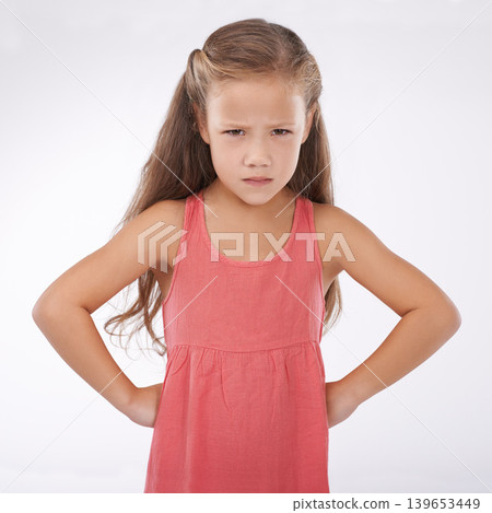 Child, portrait and unhappy grumpy in studio or bad mood discipline or development, trouble or angry. Female person, hands and hips in frustration for girl kid as white background, attitude or mockup 139653449