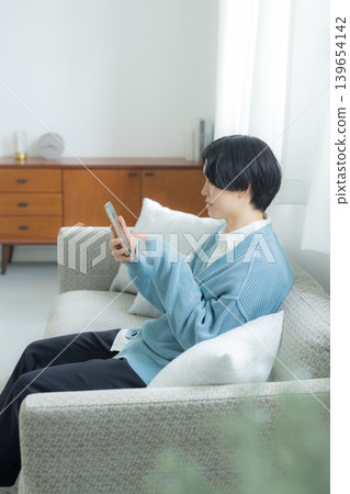 A young man operating a smartphone A young man operating a smartphone 139654142