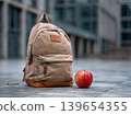 Back to school backpack with apple on campus floor, college education and learning concept 139654355