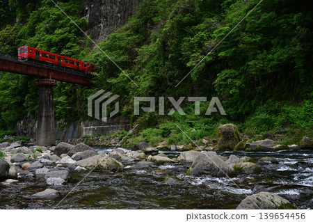 A red train running through a valley A red train running through a valley 139654456