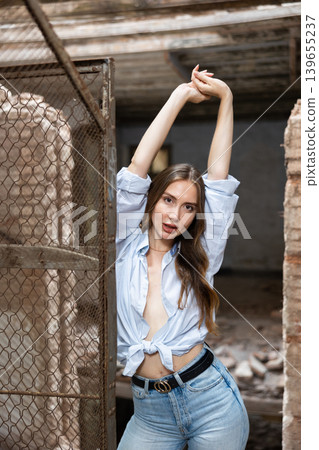 Desirable young woman posing in deserted building Desirable young woman posing in deserted building 139655237