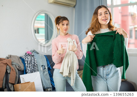 Two young women choosing clothes to wear Two young women choosing clothes to wear 139655263