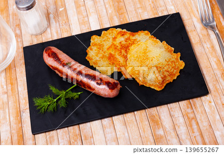 Potato pancakes with fried frankfurter on serving slate board Potato pancakes with fried frankfurter on serving slate board 139655267