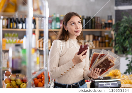Young woman scanning qr code of jamon Young woman scanning qr code of jamon 139655364