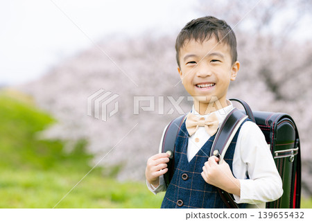 New first grader walking in the park where cherry blossoms bloom New first grader walking in the park where cherry blossoms bloom 139655432