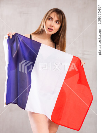 Young pretty woman proudly displaying flag of france Young pretty woman proudly displaying flag of france 139655494