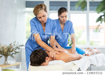 Professional masseuse teaching massage techniques to trainee 139655532