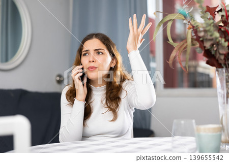 Stressed young woman using phone at home 139655542