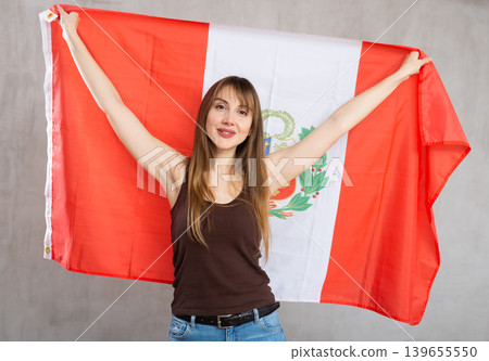 Young cheerful woman holding flag of Peru Young cheerful woman holding flag of Peru 139655550