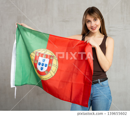 Happy woman posing with national flag of Portugal in studio Happy woman posing with national flag of Portugal in studio 139655602
