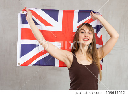 Young cheerful woman holding flag of Great Britain Young cheerful woman holding flag of Great Britain 139655612