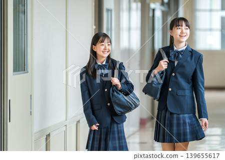 Elementary school students, junior high school students, high school students, and high school girls in uniform walking down the school corridor Elementary school students, junior high school students, high school students, and high school girls in uniform walking down the school corridor 139655617
