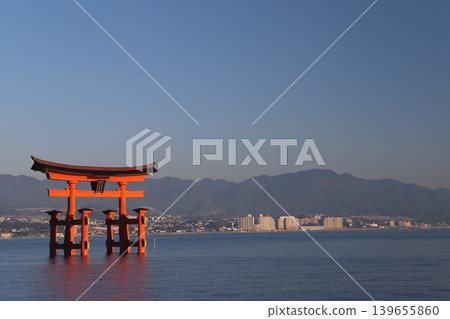 Miyajima, Hatsukaichi City, Hiroshima Prefecture: Itsukushima Shrine - The vibrant vermilion torii gate illuminated by the rising sun. Miyajima, Hatsukaichi City, Hiroshima Prefecture: Itsukushima Shrine - The vibrant vermilion torii gate illuminated by the rising sun. 139655860