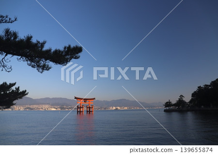 Miyajima, Hatsukaichi City, Hiroshima Prefecture: Itsukushima Shrine - The vibrant vermilion torii gate illuminated by the rising sun. Miyajima, Hatsukaichi City, Hiroshima Prefecture: Itsukushima Shrine - The vibrant vermilion torii gate illuminated by the rising sun. 139655874