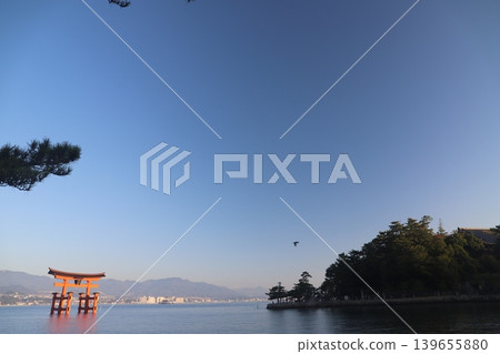 Miyajima, Hatsukaichi City, Hiroshima Prefecture: Itsukushima Shrine - The vibrant vermilion torii gate illuminated by the rising sun. Miyajima, Hatsukaichi City, Hiroshima Prefecture: Itsukushima Shrine - The vibrant vermilion torii gate illuminated by the rising sun. 139655880