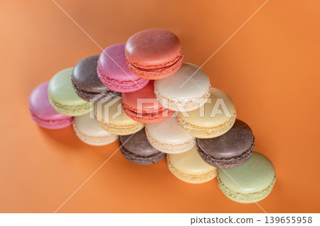 Sweet Colorful Macarons on Bright Orange Surface. Sweet Colorful Macarons on Bright Orange Surface. 139655958
