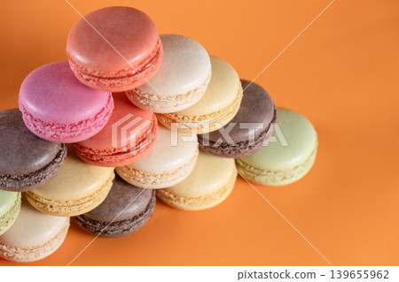 Sweet Colorful Macarons on Bright Orange Surface. Sweet Colorful Macarons on Bright Orange Surface. 139655962