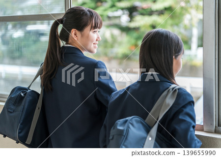 Junior high school girls in uniforms talking in the school corridor 139655990
