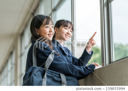 Junior high school girls in uniforms talking in the school corridor 139655994