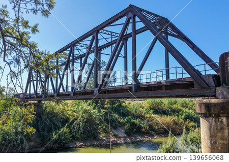 Aerial side view of the Paterson railway bridge spanning the Hunter River in New South Wales Australia. Drone photograph captures the historic rail bridge alongside the river and surrounding regional Aerial side view of the Paterson railway bridge spanning the Hunter River in New South Wales Australia. Drone photograph captures the historic rail bridge alongside the river and surrounding regional 139656068