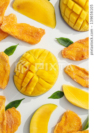 Fresh and dried mango pieces displayed with green leaves Fresh and dried mango pieces displayed with green leaves 139656105