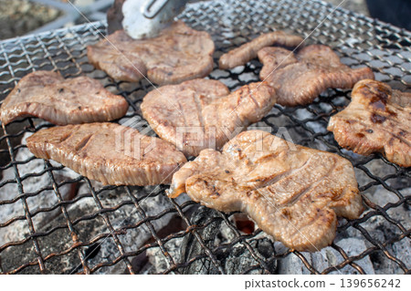 Thick-cut beef tongue grilled over charcoal on a grill outdoors Thick-cut beef tongue grilled over charcoal on a grill outdoors 139656242