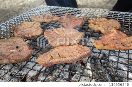 Thick-cut beef tongue grilled over charcoal outdoors Thick-cut beef tongue grilled over charcoal outdoors 139656246
