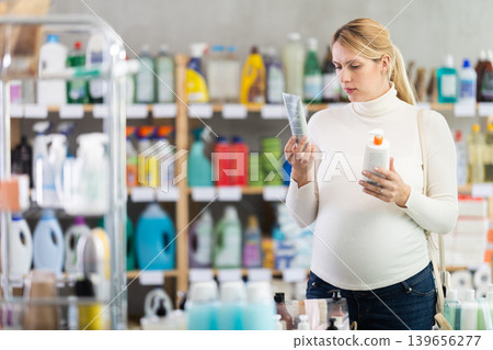 Expecting mother choosing sunscreen in personal care store Expecting mother choosing sunscreen in personal care store 139656277