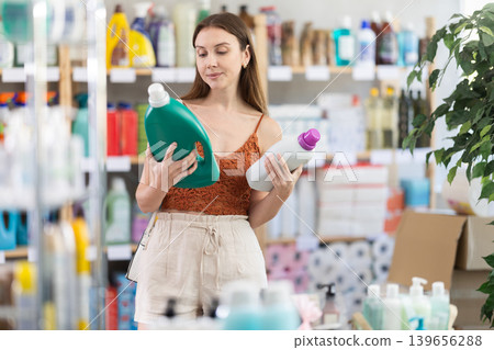 Young woman choosing laundry detergent in store during summer 139656288