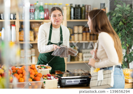 Saleswoman offers various sweets to the buyer Saleswoman offers various sweets to the buyer 139656294