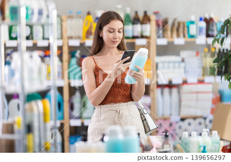 Young woman scanning qr code for shampoo or shower gel 139656297