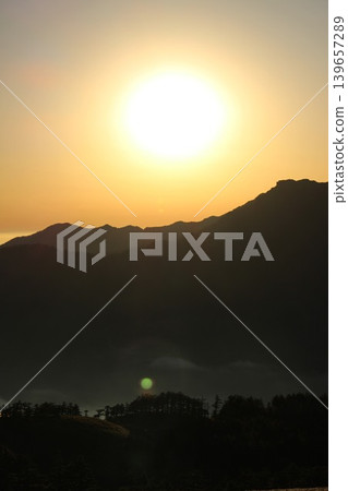 A sea of clouds illuminated by the setting sun and the silhouette of Mt. Ishizuchi, as seen from Mt. Kamegamori in the Ishizuchi mountain range of Ehime Prefecture. A sea of clouds illuminated by the setting sun and the silhouette of Mt. Ishizuchi, as seen from Mt. Kamegamori in the Ishizuchi mountain range of Ehime Prefecture. 139657289
