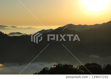 從愛媛縣石槌山脈的龜森山上看到的景象：落日餘暉照亮了雲海，映襯著石槌山的輪廓。 139657292