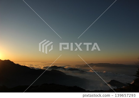 從愛媛縣石槌山脈的龜森山上看到的景象：落日餘暉照亮了雲海，映襯著石槌山的輪廓。 139657293
