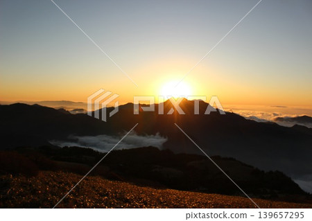 A sea of clouds illuminated by the setting sun and the silhouette of Mt. Ishizuchi, as seen from Mt. Kamegamori in the Ishizuchi mountain range of Ehime Prefecture. A sea of clouds illuminated by the setting sun and the silhouette of Mt. Ishizuchi, as seen from Mt. Kamegamori in the Ishizuchi mountain range of Ehime Prefecture. 139657295