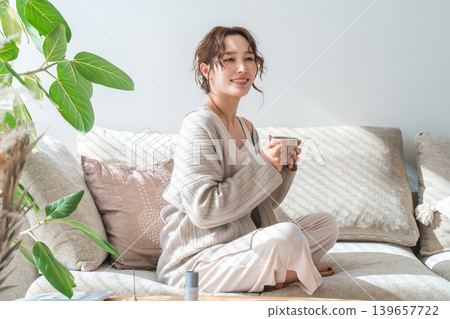 時尚女性坐在沙發上喝熱飲 139657722