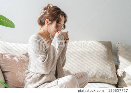 時尚女性坐在沙發上喝熱飲 139657727