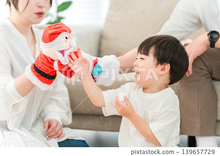 家長和孩子們在玩聖誕老人玩偶和毛絨玩具。 家長和孩子們在玩聖誕老人玩偶和毛絨玩具。 139657729